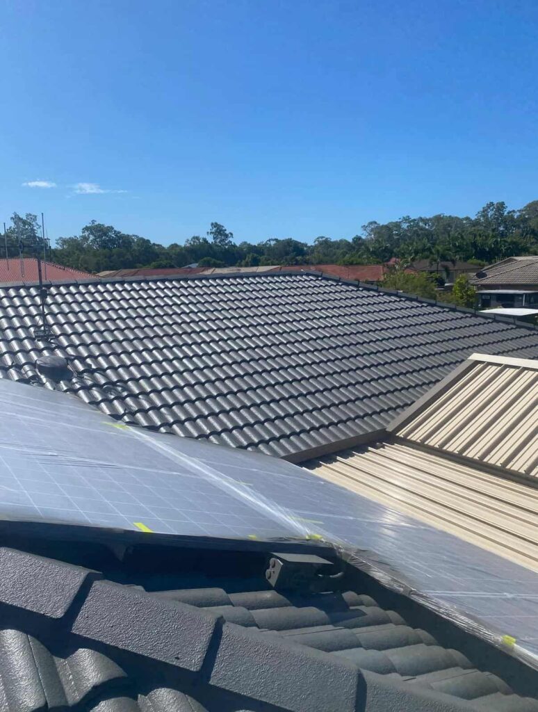 Recently painted tile roof showcasing precision work around wrapped solar panels